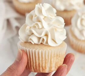 gluten free vanilla cupcakes dairy free, A hand is holding a vanilla cupcake that is topped with white fluffy buttercream frosting