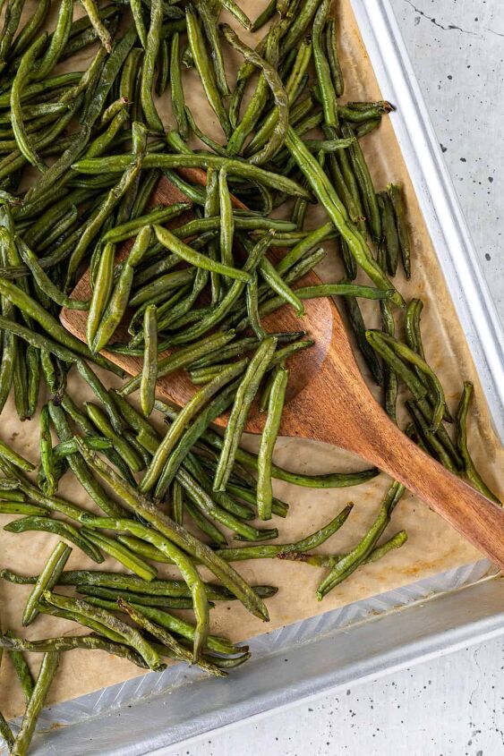 roasted frozen green beans, A parchment lined tray of roasted green beans with a spatula