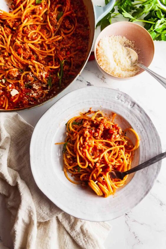 easy one pot spaghetti and meat sauce, Overhead image of one pot spaghetti with meat sauce and a small dish of grated parmesan cheese