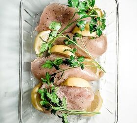 perfect oven baked chicken breasts, boneless chicken breasts with lemon and parsley in a glass baking dish