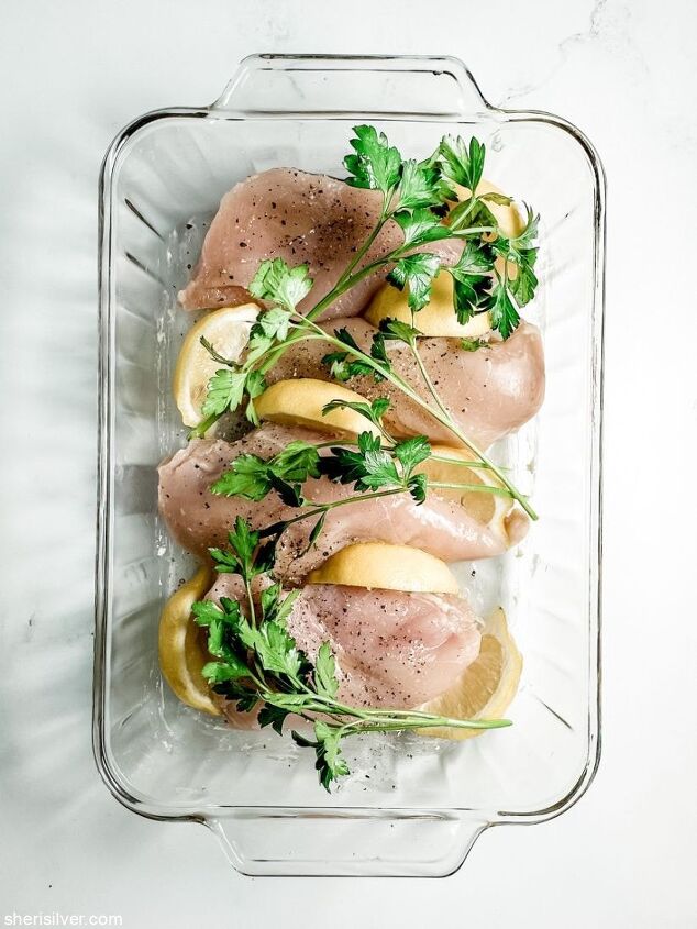 perfect oven baked chicken breasts, boneless chicken breasts with lemon and parsley in a glass baking dish
