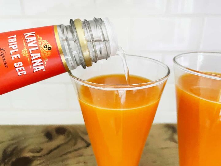 carrot mimosa, Pouring triple sec into a glass with carrot juice
