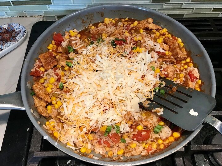 mexican marinated chicken and rice skillet, Shredded cheese added to Mexican Marinated Chicken and Rice skillet on stove
