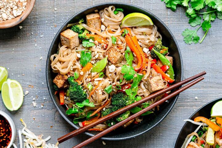 vegan pad thai with marinated tofu, vegetarian pad thai served with chopsticks garnished with cilantro and lime