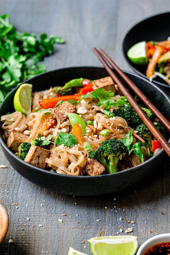 vegan pad thai with marinated tofu, vegetarian pad thai served with chopsticks garnished with cilantro and lime