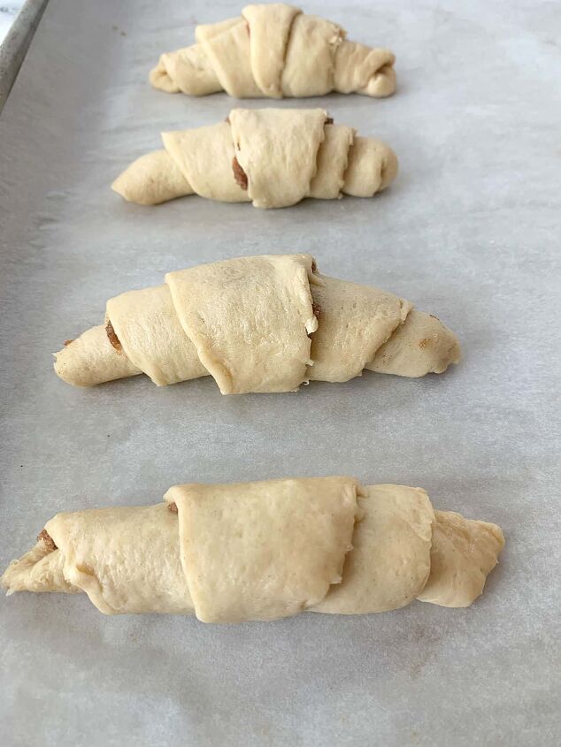 crescent roll cinnamon rolls, Four unbaked crescent rolls on a cookie sheet