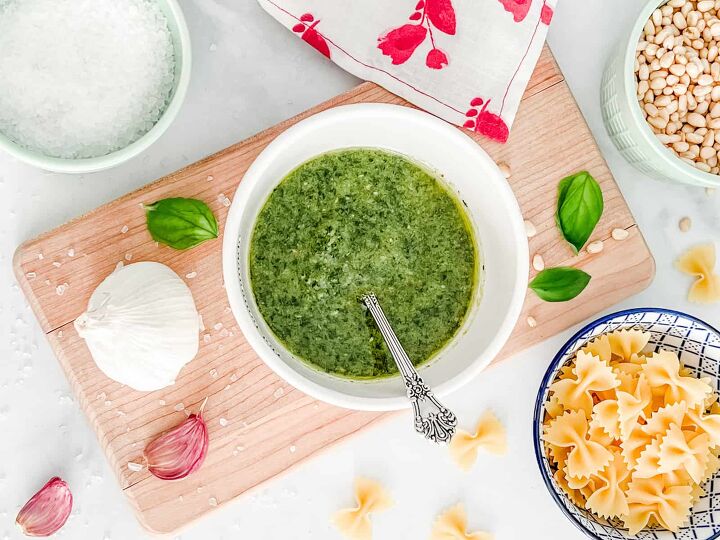 the perfect wine pairings for pesto sauce, Pesto sauce in a white bowl with ingredients surrounding it