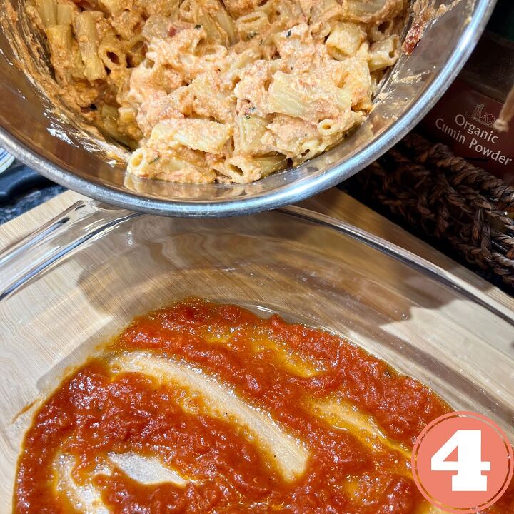 ww meatless baked ziti, Cheesy ziti being poured into a saucy casserole dish
