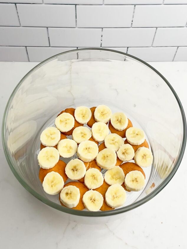 how to make easy banana pudding, nilla wafers and bananas layered in a trifle bowl