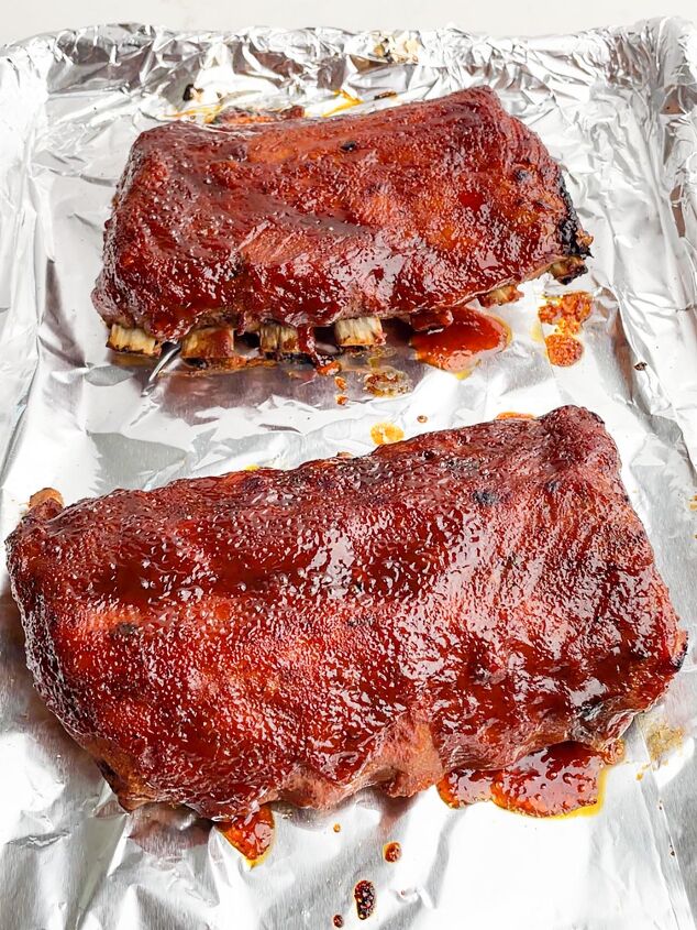 dr pepper crock pot ribs, two half racks of ribs on a foil lined baking sheet