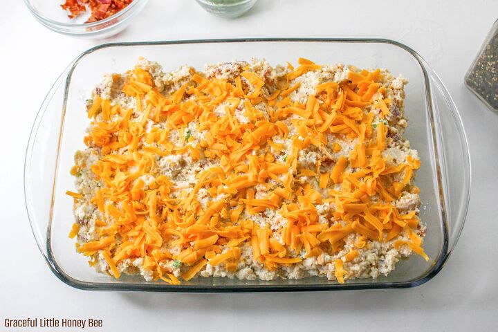 easy and delicious loaded baked potato casserole, Aerial view of Loaded Baked Potato Casserole sprinkled with cheese before going into the oven