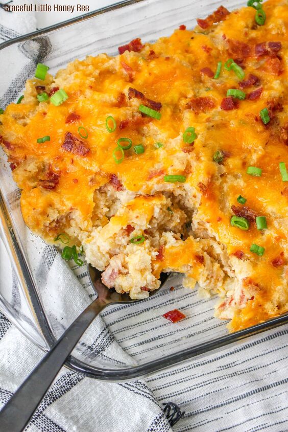 easy and delicious loaded baked potato casserole, A close up of Loaded Baked Potato Casserole in a casserole dish with one serving gone and a spoon in it s place
