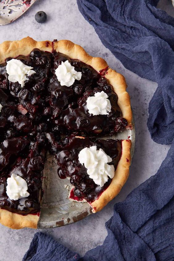 recipe for fresh blueberry pie that s not runny, A pie pan of fresh blueberry pie topped with whipped cream