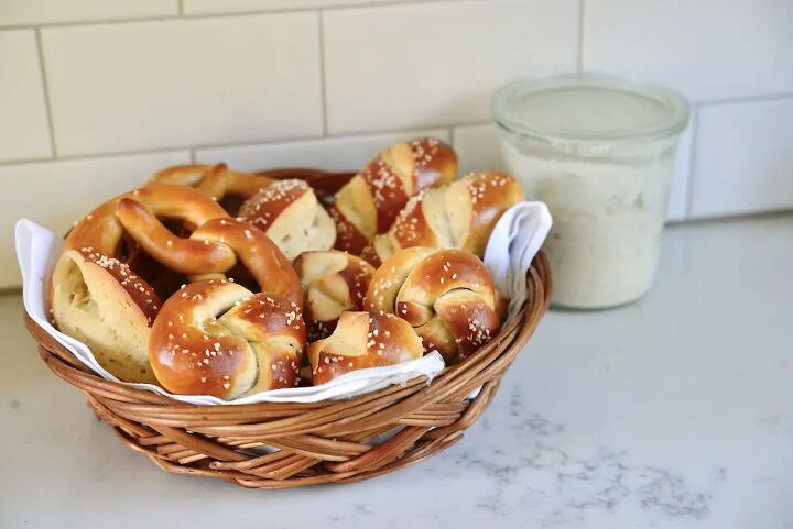 easy soft sourdough pretzels, sourdough pretzel shapes in basket with sourdough starter in background