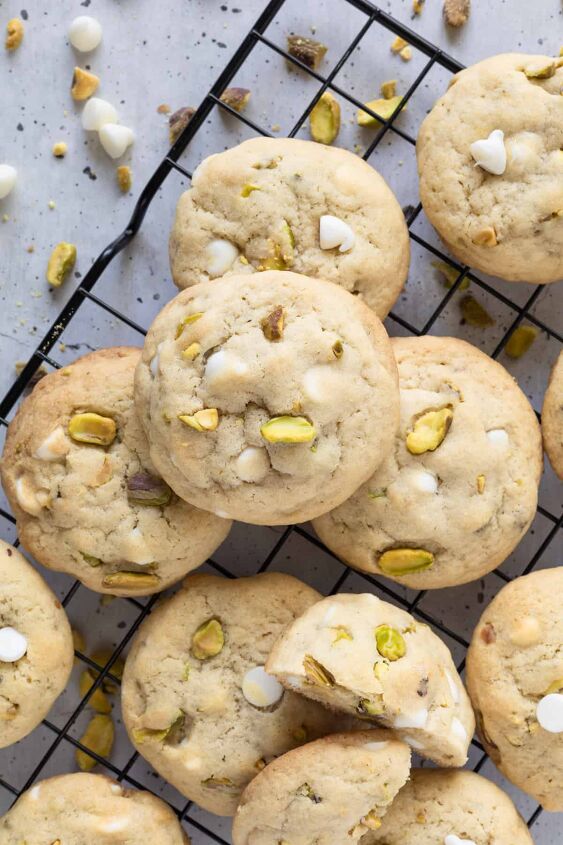 pistachio white chocolate cookies, An array of pistachio white chocolate cookies on a wire cooling rack