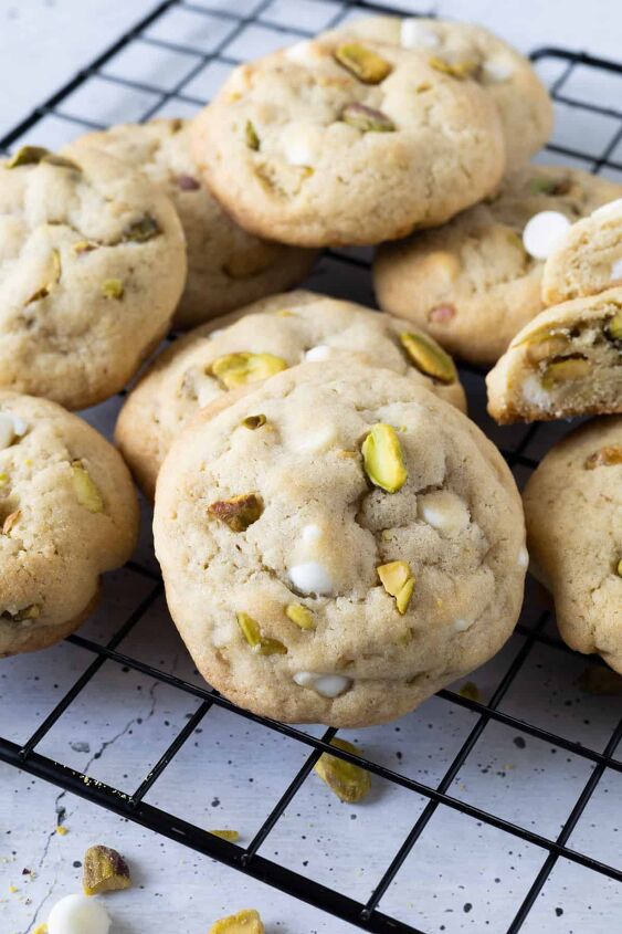 pistachio white chocolate cookies, A pile of cookies on a wire cooling rack
