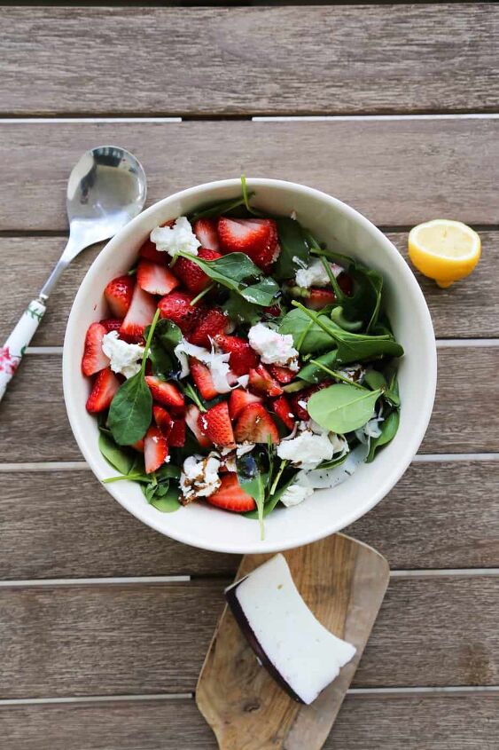 strawberry and goat cheese salad, strawberry and goat cheese salad with a lemon and cheese on a cutting board