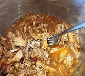 instant pot salsa chicken only 3 ingredients, fork in the pot stirring to break up and shred the cooked chicken