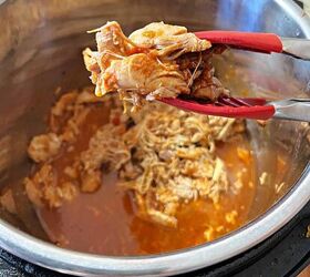 instant pot salsa chicken only 3 ingredients, a tongs holding shredded salsa chicken over the instant pot full of more meat