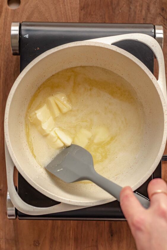 salted bourbon caramels, A spatula stirs melting butter in a pot