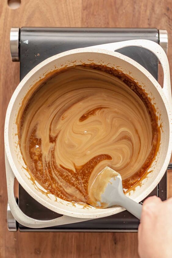 salted bourbon caramels, A spatula stirs sweetened condensed milk into a pot
