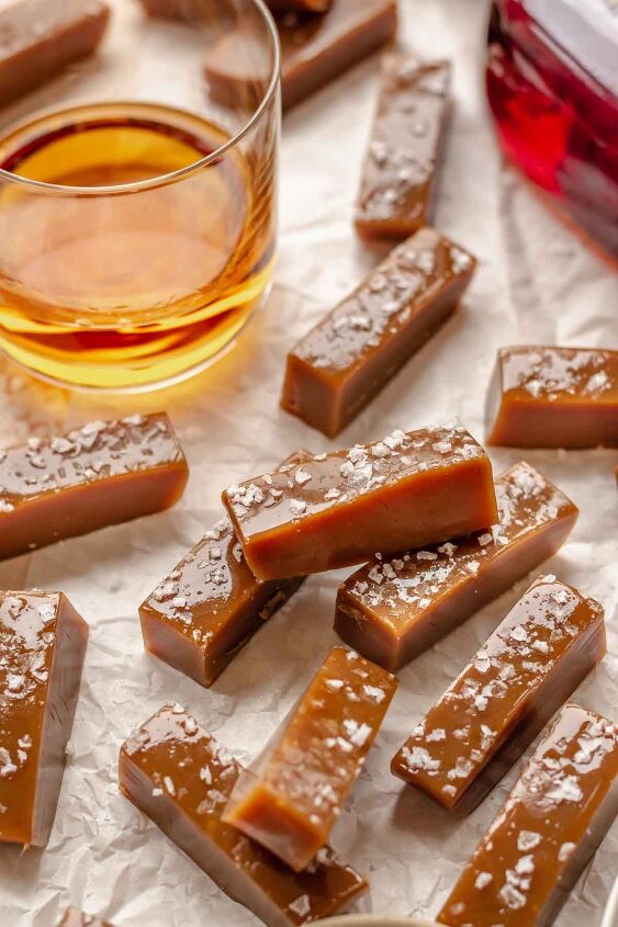 salted bourbon caramels, Salted whiskey caramels laid about with a glass of whiskey in the back