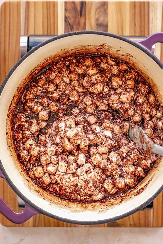 chocolate rice krispie treats, A spatula stirs marshamllows into chocolate in a pot
