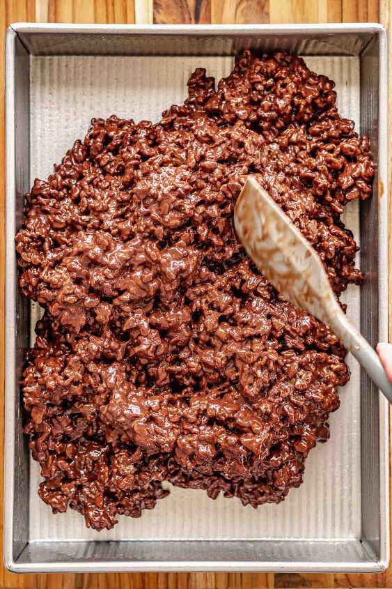 chocolate rice krispie treats, A spatula spreads chocolate Rice Krispies into a pan