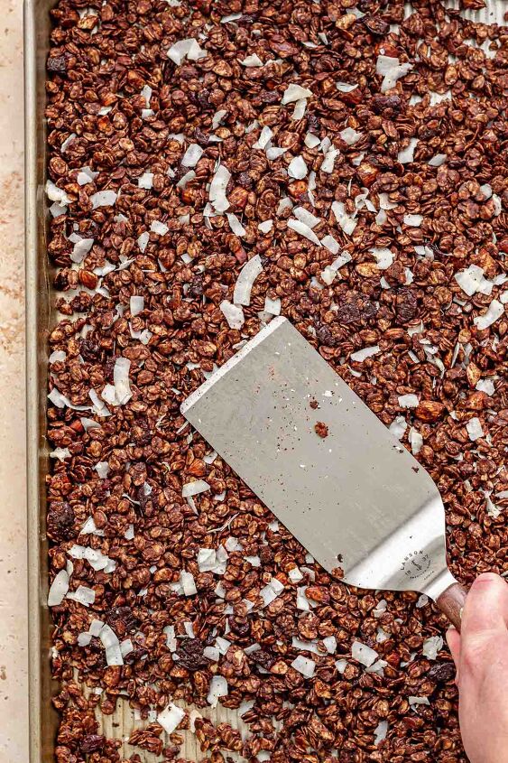 dark chocolate granola, A spatula pushes down granola on a sheet pan