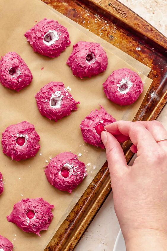 chocolate raspberry truffles with raspberry filling, A hand adds frozen dollops of raspberry puree into each candy