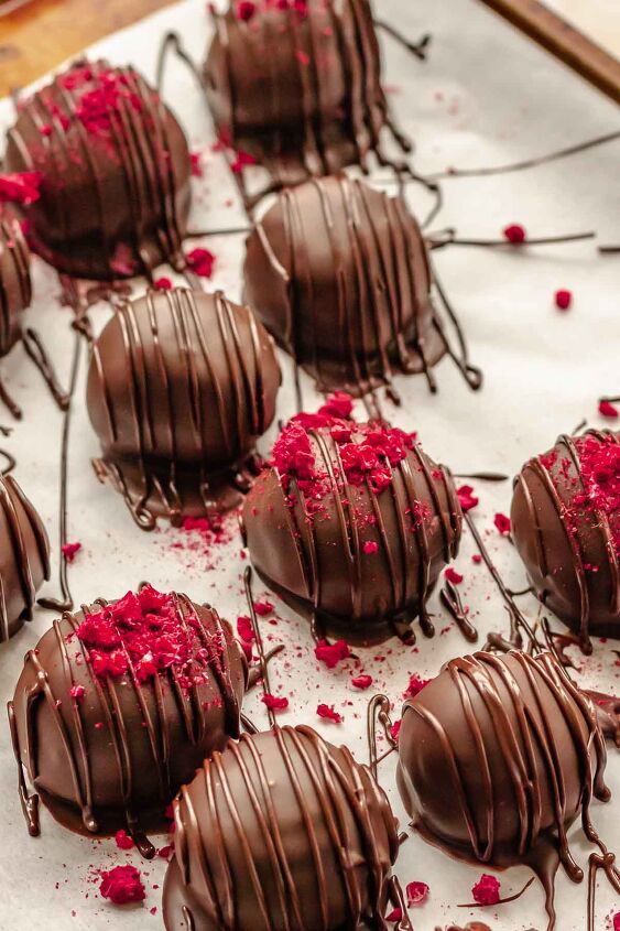 chocolate raspberry truffles with raspberry filling, Chocolate raspberry truffles on a sheet pan Some have freeze dried raspberry crumbles on top