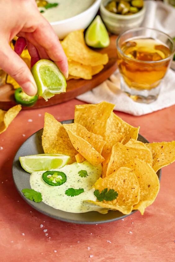 creamy jalapeno ranch dip, A hand squeezes a lime over chips and dip in a bowl