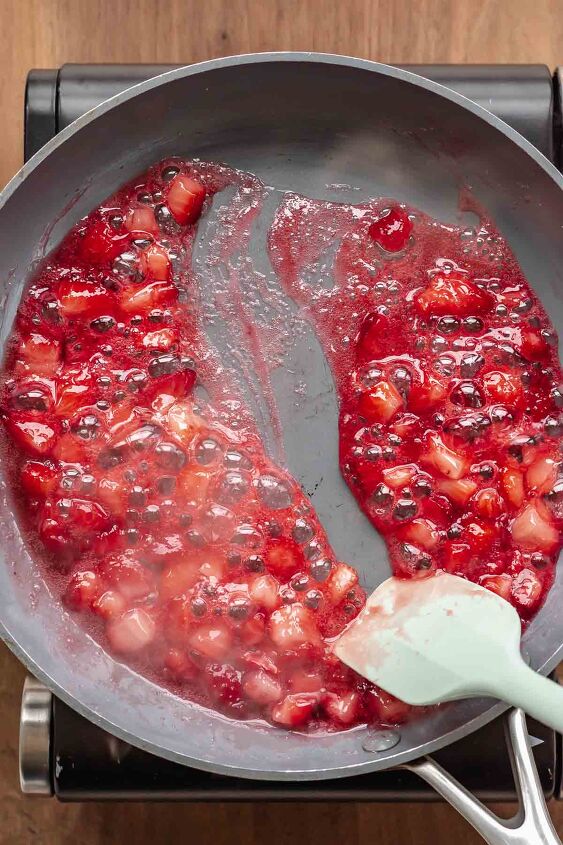 strawberry stuffed french toast, Strawberry syrup in a pan with a spatula stirring