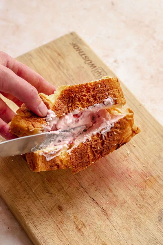 strawberry stuffed french toast, A hand uses a knife to add strawberry cream cheese into the brioche bread pocket