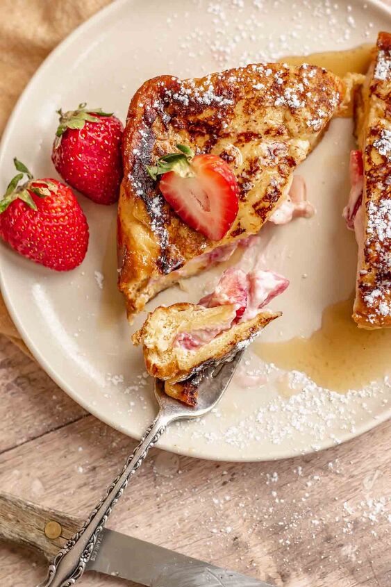 strawberry stuffed french toast, French toast on a plate with a fork holding a bite
