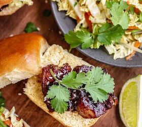 braised pork belly sliders with asian slaw, Pork belly on a bun with cilantro on top and asian slaw on the side
