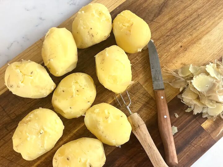 easy german fried potatoes bratkartoffeln, peeled potatoes on cutting board with knife and potato pick