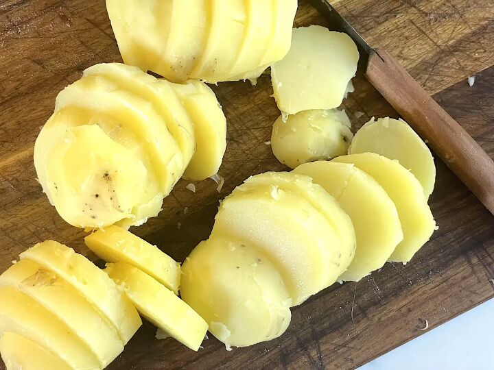 easy german fried potatoes bratkartoffeln, sliced potatoes on cutting board with knife