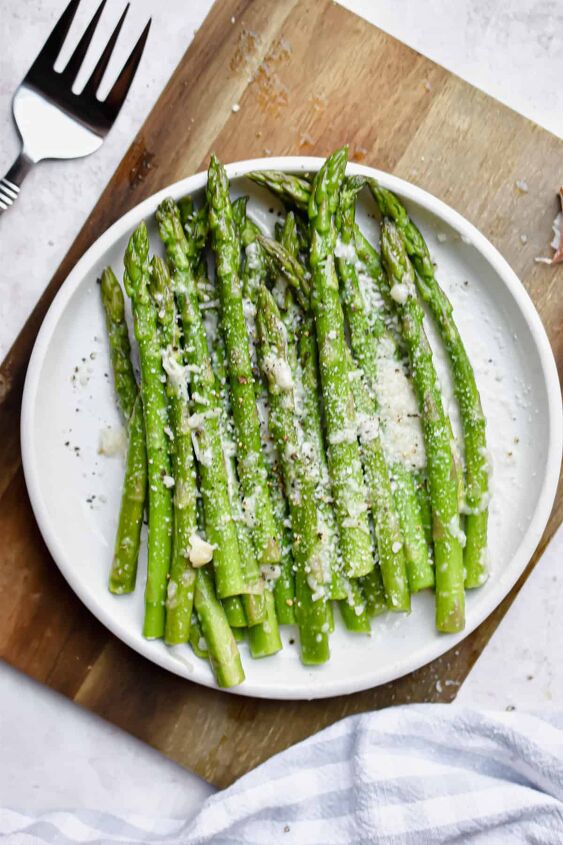simple steamed instant pot asparagus, A plate of Instant Pot Asparagus are on a white plate on a cutting board