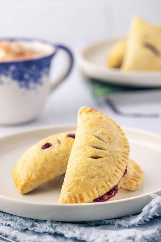 sweet cherry hand pies, Three baked hand pies on a white plate