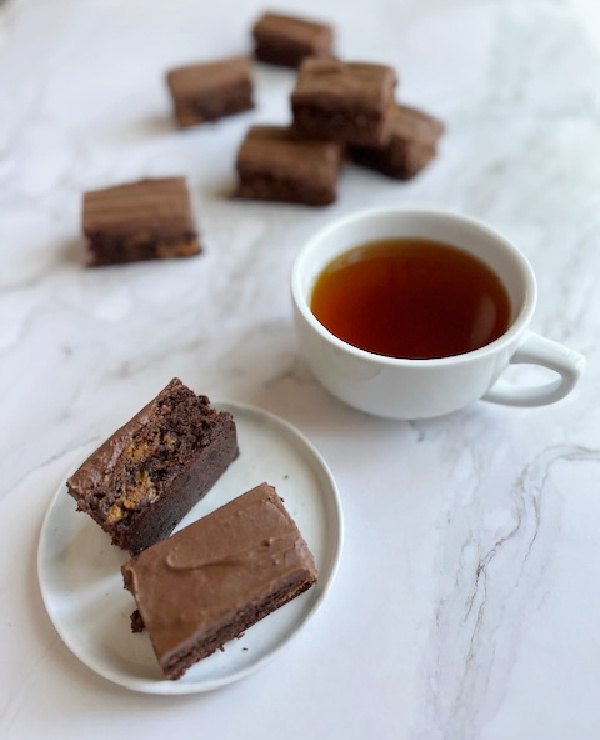 dulce de leche brownies, dulce de leche brownies on a stack and two on a plate with a cup of tea