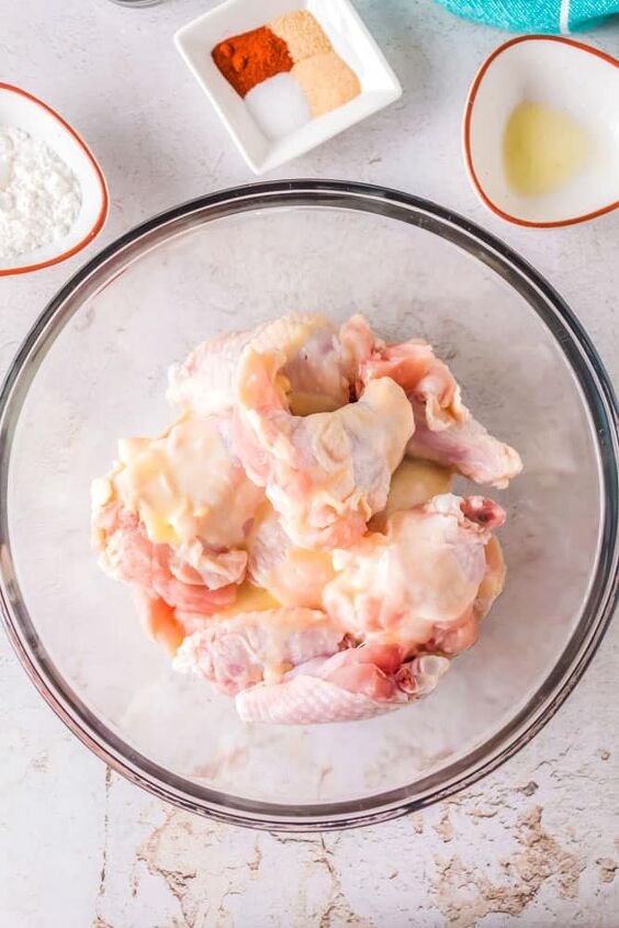 crispy air fryer chicken wings with cornstarch, Raw chicken wings in a bowl with melted butter over the top
