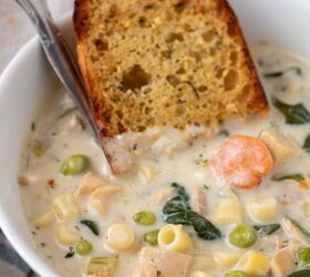 instant pot creamy chicken soup, A white soup bowl filled with creamy chicken soup There s a piece of garlic bread dipped in the bowl with a silver spoon