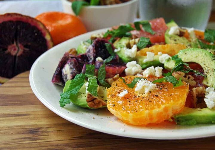 white plate with salad of oranges and avocado
