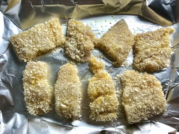 crispy baked cod panko fish and chips, Raw cod fish breaded on a sheet pan lined with aluminum before being baked for Crispy Baked Cod Panko Fish and Chips