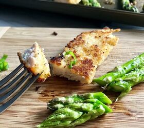 Parmesan breadcrumb chicken on cutting board with bite on fork and asparagus cut
