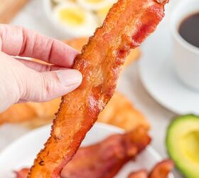how to cook bacon in the air fryer, hand holding a slice of bacon cooked in the air fryer