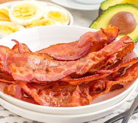 how to cook bacon in the air fryer, Bacon cooked in the air fryer on a plate with eggs and avocados on side plates