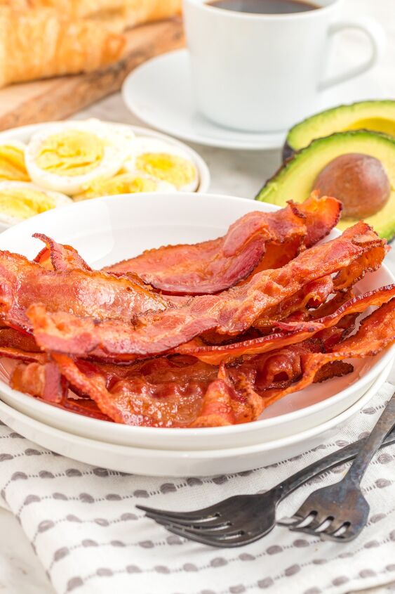 how to cook bacon in the air fryer, Bacon cooked in the air fryer on a plate with eggs and avocados on side plates