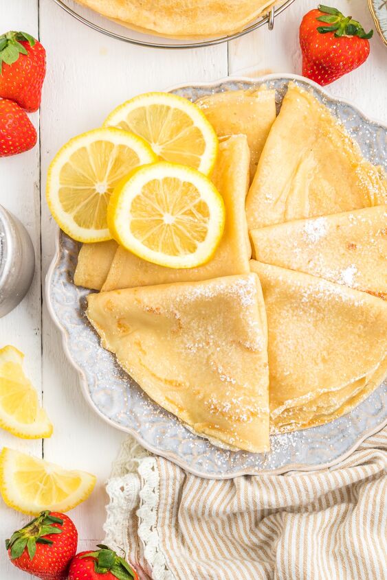 parisian crepes will make you the star of brunch, Parisian Cr pes on a plate with lemon slices and strawberries on the table
